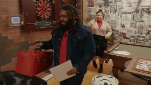 Jah carries the red box with Winter Everett behind him