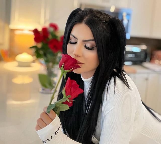 Larissa lima smells a red rose